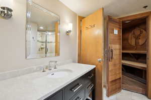 Full bath featuring a sauna, tile patterned floors, vanity, and a shower