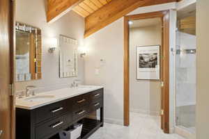 Full bath featuring a shower stall, double vanity, a sink, and beam ceiling