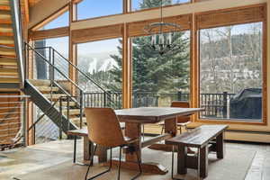 Sunroom with an inviting chandelier and baseboard heating