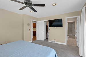 Carpeted bedroom featuring connected bathroom, recessed lighting, baseboards, a spacious closet, and visible vents