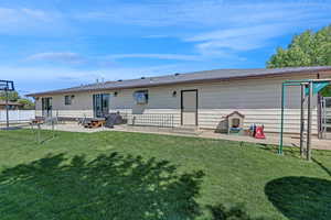 Rear view of house with a yard, entry steps, fence, and a patio area