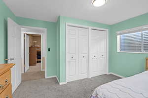 Bedroom featuring baseboards, carpet flooring, and two closets