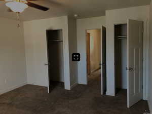 Unfurnished bedroom with baseboards, carpet flooring, and multiple closets