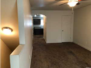 Living Room featuring arched walkways, ceiling fan, and baseboards
