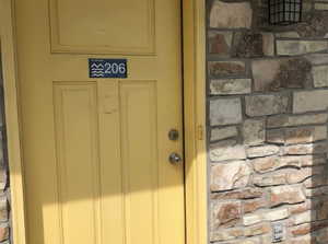 Entrance to property featuring stone siding