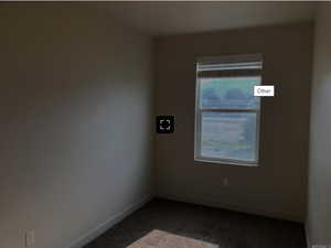 Spare room with baseboards and dark colored carpet