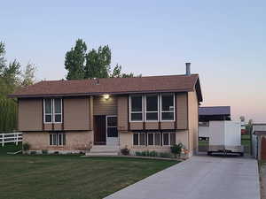 Front view with large driveway, 2 sheds and side parking