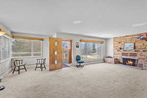 Unfurnished room featuring carpet floors, baseboards, and a fireplace
