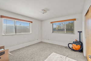 Spare room featuring carpet floors and baseboards
