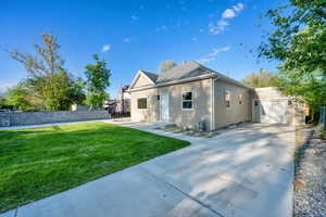 View of front of property with a garage, a front lawn, fence, and concrete driveway
