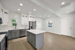 Kitchen with visible vents, a sink, black appliances, recessed lighting, and light wood-style flooring