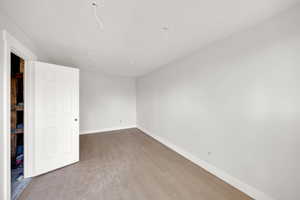 Unfurnished bedroom with baseboards and wood finished floors