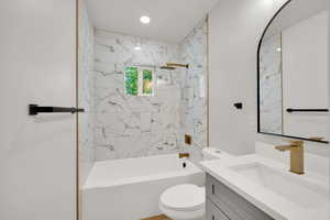 Bathroom featuring vanity, toilet, and shower / washtub combination