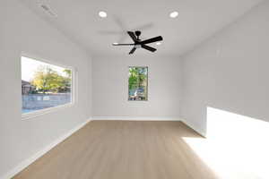 Spare room featuring a ceiling fan, visible vents, light wood-type flooring, baseboards, and recessed lighting