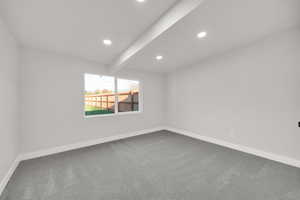 Spare room featuring recessed lighting, baseboards, beam ceiling, and dark carpet