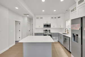 Kitchen featuring recessed lighting, a sink, gray cabinets, and stainless steel appliances