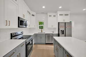 Kitchen featuring stainless steel appliances, gray cabinetry, a sink, and recessed lighting