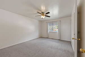 Empty room with baseboards, ceiling fan, and light colored carpet