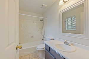 Full bath featuring shower / bathtub combination, toilet, tile patterned floors, and vanity