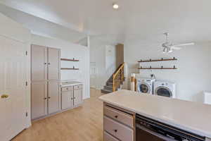 Kitchen featuring washer and dryer, open shelves, ceiling fan, light wood finished floors, and dishwasher