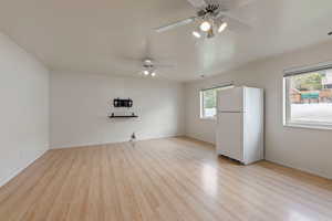 Empty room featuring ceiling fan and light wood finished floors