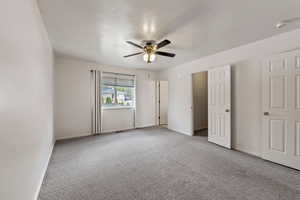 Unfurnished bedroom featuring carpet floors, a ceiling fan, and baseboards