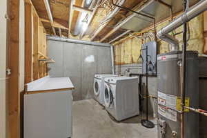 Laundry area with laundry area, gas water heater, and washing machine and dryer