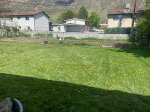 View of yard featuring fence and a mountain view