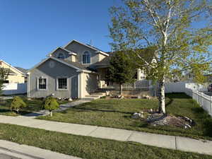 View of front of home featuring fence, stucco siding, and a front yard