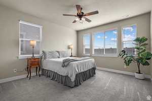 Bedroom featuring carpet flooring, baseboards, visible vents, and ceiling fan