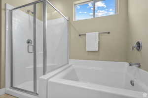 Bathroom featuring a shower stall and a bath