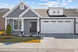 View of front of home featuring a garage, board and batten siding, roof with shingles, and driveway