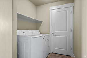 Laundry room with laundry area, dark wood-style flooring, and washer and clothes dryer