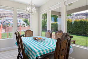 Dining space featuring baseboards, wood finished floors, and a notable chandelier