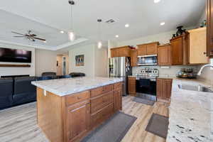 Kitchen featuring visible vents, arched walkways, a sink, light wood finished floors, and appliances with stainless steel finishes
