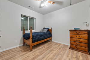 Bedroom featuring baseboards, visible vents, ceiling fan, and light wood-type flooring