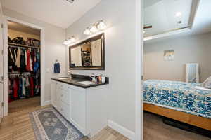 Full bathroom featuring vanity, recessed lighting, wood finished floors, and a spacious closet