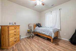 Bedroom with ceiling fan, baseboards, visible vents, and light wood-style flooring