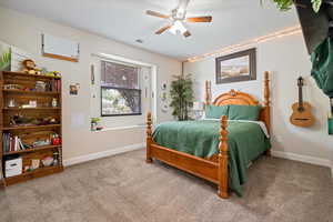 Bedroom featuring carpet flooring, ceiling fan, visible vents, and baseboards