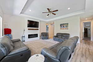Living area with recessed lighting, ceiling fan, visible vents, and a raised ceiling