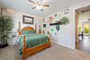 Carpeted bedroom with baseboards, a ceiling fan, and visible vents