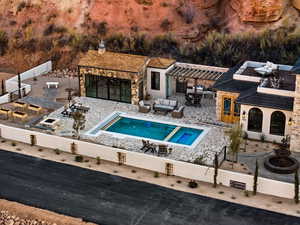 View of pool with an outbuilding, a patio area, fence, a bar, and an outdoor hangout area