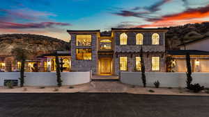 View of front of property featuring a fenced front yard, a mountain view, and stone siding