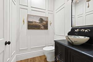 Bathroom featuring vanity, wood finished floors, and toilet