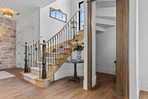 Stairs featuring baseboards, visible vents, and wood finished floors