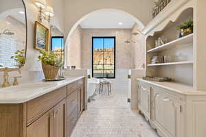 Bathroom with a sink, a freestanding tub, a shower stall, and double vanity