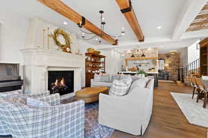 Living area with beam ceiling, a fireplace, stairs, recessed lighting, and wood finished floors