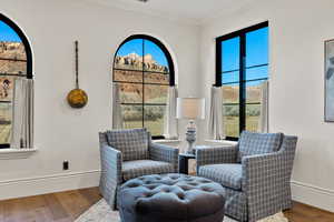Sitting room with baseboards, ornamental molding, wood finished floors, and a wealth of natural light