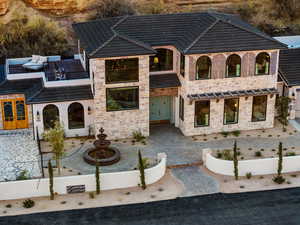 View of front of home featuring stone siding and a balcony