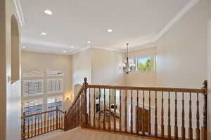 Hallway with an inviting chandelier, recessed lighting, carpet floors, and an upstairs landing